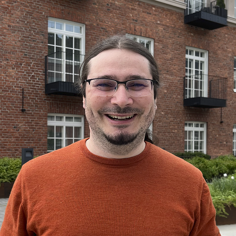 Rémi Duflot, taustalla tiiliseinäinen rakennus